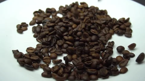 Coffee beans are falling on the white plate. Slow motion Stock Footage 86214607