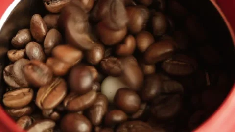 Coffee beans are poured into the grinder against the background of coffee beans Stock Footage 316089504
