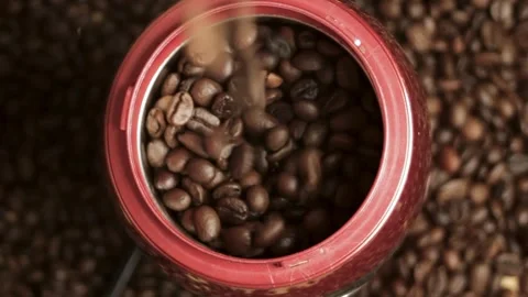 Coffee beans are poured into the grinder against the background of coffee beans Stock Footage 316089646