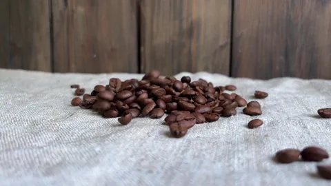 Coffee beans are pouring onto the tablecloth. Stock Footage 281465821