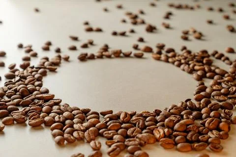 Coffee beans arranged in a circular pattern on a white surface Stock Photos