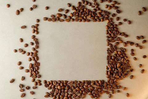 Coffee beans arranged creatively on a surface form an empty frame Stock Photos