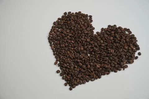 Coffee beans arranged in heart shape on white background Foto stock
