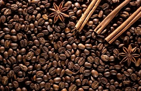 Coffee beans background with different spices: anise stars and cinnamon stick Stock Photos