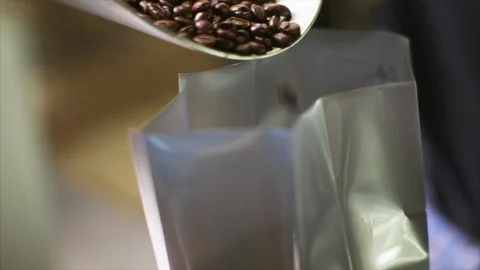 Coffee beans being poured into a bag. Video stock 88405132