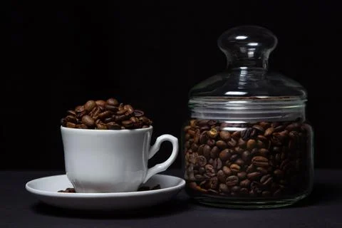 Coffee beans on a black background. A coffee cup full of coffee beans Stock Photos