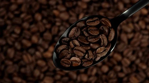 Coffee beans in black spoon. coffee beans background rotation left Stockbeeldmateriaal 129799125