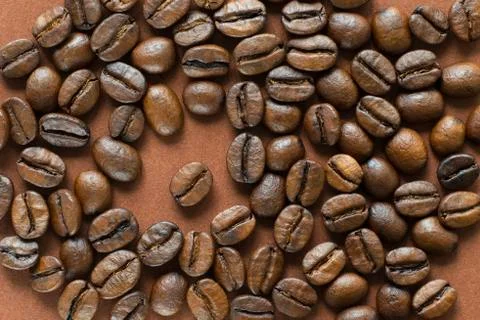 Coffee beans on brown background close up Stock Photos