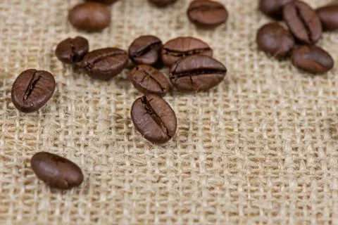 Coffee beans on burlap background close up 스톡 사진
