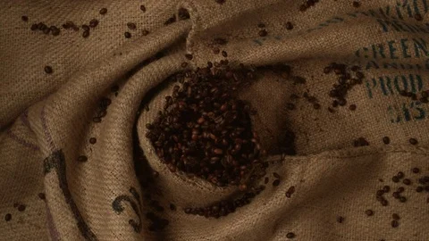 Coffee beans in burlap bag fly after being exploded. Slow Motion. Stock Footage 79734727
