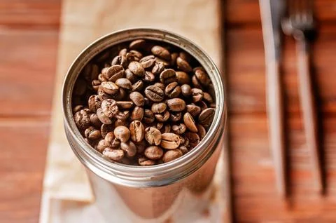 Coffee beans in a can. Roasted aromatic coffee close-up. Sunlight on backgrou Stock Photos