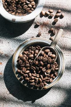 Coffee beans in a ceramic plate on a gray background. Stock Photos