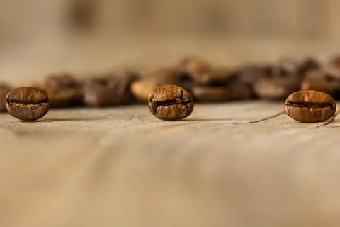 Coffee beans from close range on an old wooden table. Stock Photos