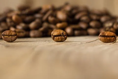 Coffee beans from close range on an old wooden table. Stock Photos