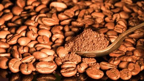 Coffee beans close-up with a spoon of ground coffee on a mirror background. Stock Photos