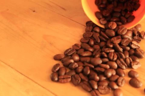 Coffee beans in coffee container isolated on wooden Foto stock