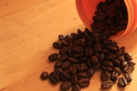 Coffee beans in coffee container isolated on wooden Foto stock