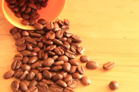 Coffee beans in coffee container isolated on wooden Foto stock