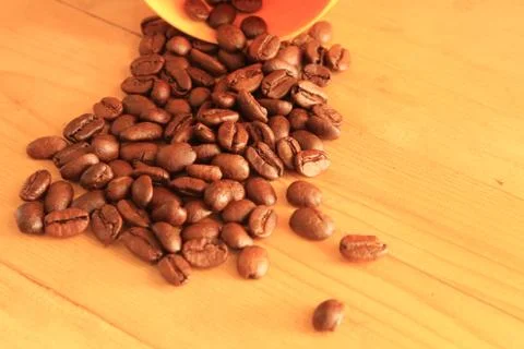 Coffee beans in coffee container isolated on wooden Foto stock