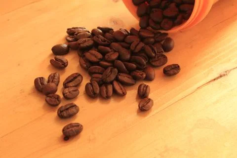 Coffee beans in coffee container isolated on wooden Foto stock