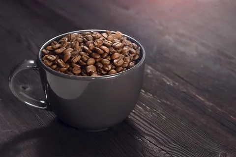 Coffee beans in coffee cup on background Фото