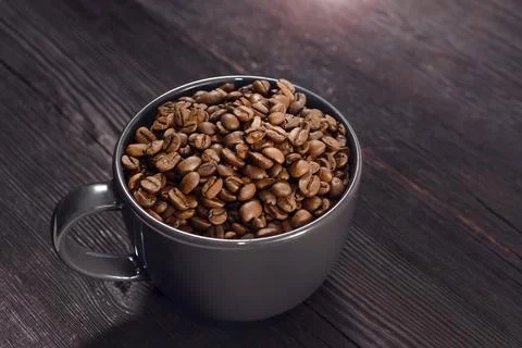 Coffee beans in coffee cup on background Фото