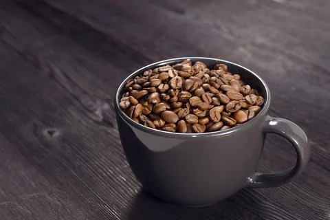 Coffee beans in coffee cup on background Фото
