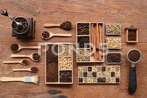 Coffee beans with coffee grinder and ground coffee in wooden spoon Stock Photos