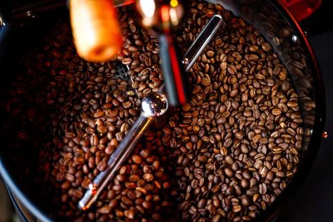 Coffee beans in a coffee machine, in dark colors. Stock Photos