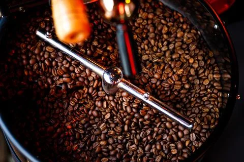 Coffee beans in a coffee machine, in dark colors. Stock Photos