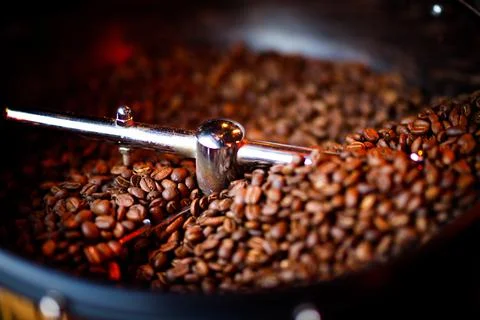 Coffee beans in a coffee machine, in dark colors. 库存照片