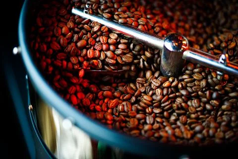 Coffee beans in a coffee machine, in dark colors. 库存照片