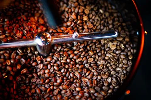 Coffee beans in a coffee machine, in dark colors. Stock Photos