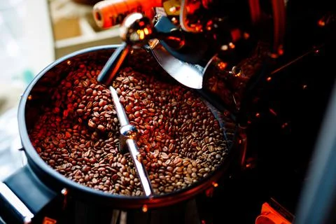 Coffee beans in a coffee machine, in dark colors. 库存照片