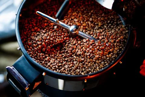 Coffee beans in a coffee machine, in dark colors. Stock Photos