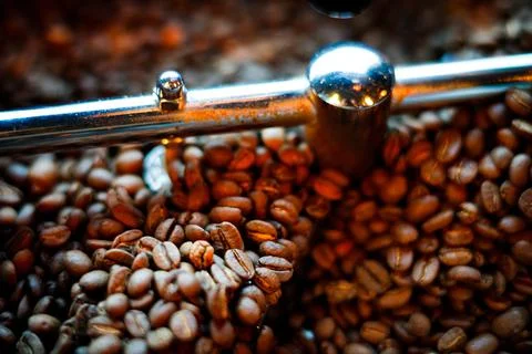 Coffee beans in a coffee machine, in dark colors. Stock Photos