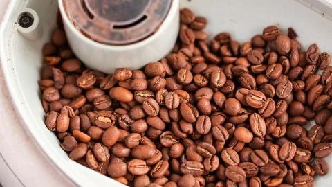 Coffee beans into coffee machine dispenser before preparing coffee. Stock Photos