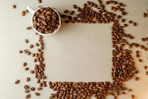 Coffee beans create a cozy frame around a white cup filled with aroma Stock Photos