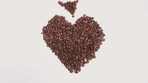 Coffee beans create a heart, a smile and a cup in stop motion. The coffee beans  Stock Footage