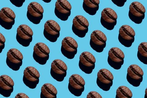 Coffee beans creative pattern isolated on blue background. Top view. roasted 스톡 사진