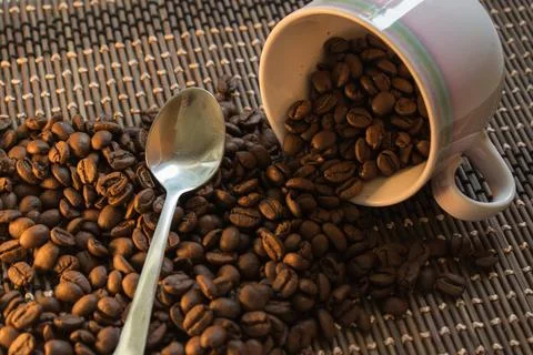 Coffee Beans Cup Background spilling over Stock Photos