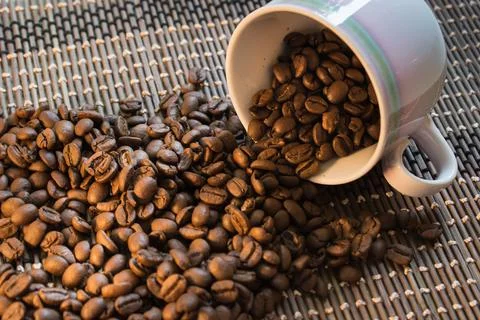 Coffee Beans Cup Background spilling over Stock Photos