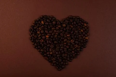 Coffee in beans on dark background. Coffee beans in the form of heart. Abstra Stock Photos