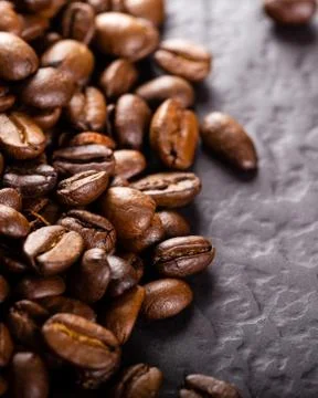 Coffee beans on dark stone table. Stock Photos