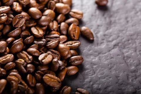 Coffee beans on dark stone table. Stock Photos