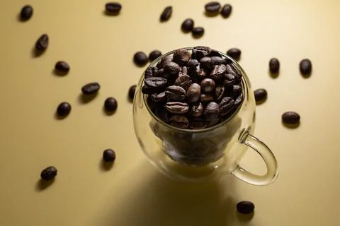 Coffee beans in double-walled espresso shot glass on plain background 스톡 사진