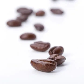 Coffee beans draw a zigzag line isolated on white. soft focus. Stock Photos