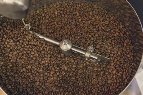 Coffee beans during the roasting process inside the hopper drum type roaster Foto stock