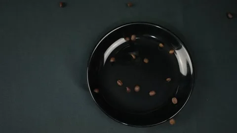 Coffee beans fall on a black plate on a black background Vídeos de archivo 150861467