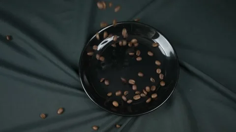 Coffee beans fall on a black plate on a black background Vídeos de archivo 150861637